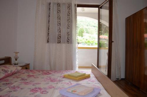 a bedroom with a bed with two towels on it at Apartments Drita in Baška