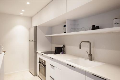 a kitchen with white cabinets and a sink at RENOVATED LARGE 3RM APARTMENT 5 MIN FROM THE BEACH in Tel Aviv