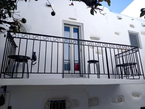 a white building with a balcony with chairs on it at Tristrato in Parikia