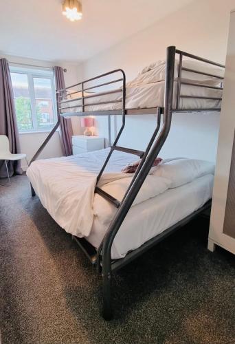 a bedroom with two bunk beds in a room at Beachside Home - Sleeps 5 Garden Parking & Pets in Skegness