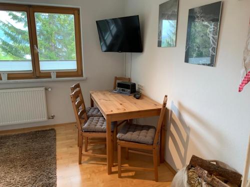 a dining room table with two chairs and a television at Alpenapart Seefeld in Seefeld in Tirol