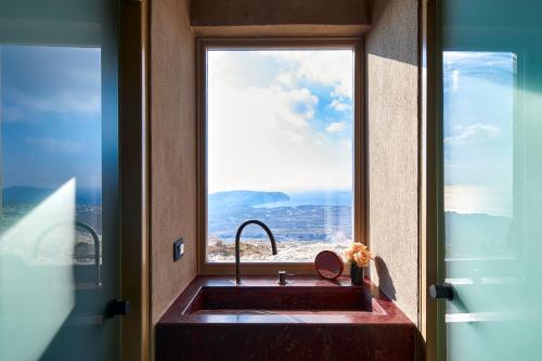 a kitchen sink with a window in a room at Santorini Sky, The Lodge in Pirgos