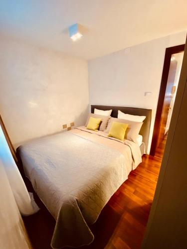 a bedroom with a large white bed with yellow pillows at Suite300 by Palazzina300 in Treviso