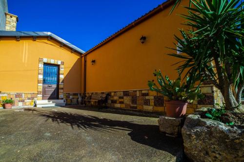 a yellow building with a palm tree in front of it at L' Antica Trebbia - Rooms in Caltanissetta