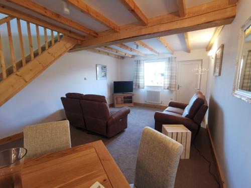 a living room with a couch and chairs and a table at The Trotting Mare Holiday Lets - Adults Only in Wrexham