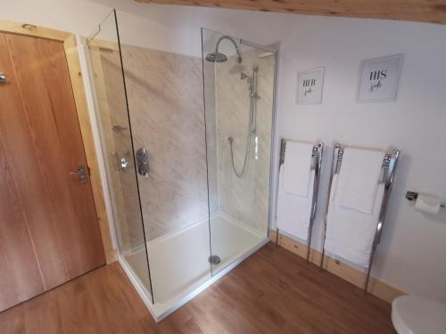 a bathroom with a shower with a glass shower stall at The Trotting Mare Holiday Lets - Adults Only in Wrexham