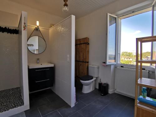 uma casa de banho com um lavatório, um WC e uma janela. em L'Échappée du Merlou em Laurède