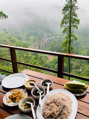 a wooden table with plates of food and spoons on it at Barn Hills in Ella