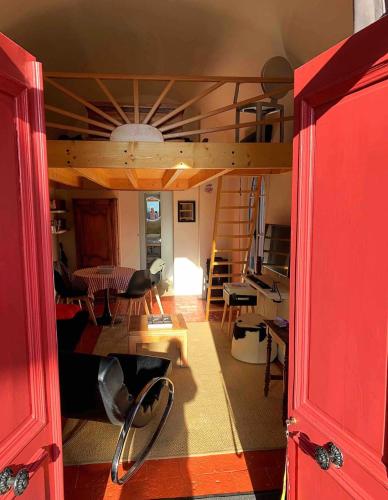 a room with a loft bed and a living room at Le petit Chapitre in Pinterville