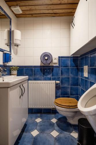 a blue tiled bathroom with a toilet and a sink at Private Villa with indoor pool in Budapest