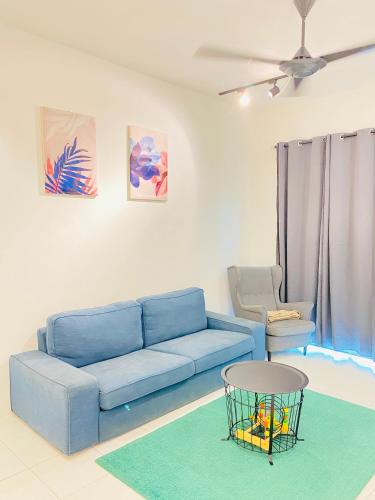 een woonkamer met een blauwe bank en een stoel bij The Quintet Condominiums 3A-1 in Cameron Highlands