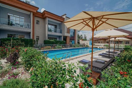 een zwembad met parasols en ligstoelen naast een hotel bij Heaven Restaurant & Boutique Hotel in Kigali