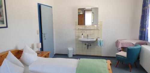 um quarto com uma cama, um lavatório e um espelho em Ferienwohnung Friedrich em Michelstadt