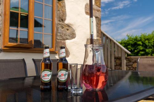 tres botellas de cerveza sentadas encima de una mesa en Yr Eifl Cottage, en Llanfairpwllgwyngyll
