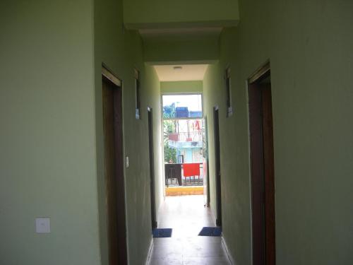 an empty hallway with green walls and a hallway with a doorway at Harry Guest House & Restaurant in Pokhara