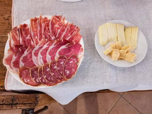 a plate of bacon and cheese on a table at B&B Ca' Restom in Reggio Emilia
