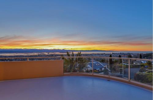 a view of a sunset from the balcony of a house at Citrus Grove in Nelson