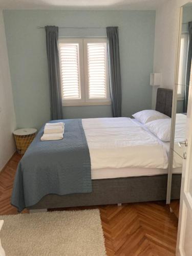 a bedroom with a bed with two towels on it at Apartment More 13 in Rabac