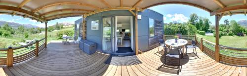 a house with a wooden floor and a wooden deck at Camping-Hotel de Plein Air Les 2 Bois in Baratier