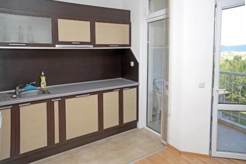 a kitchen with a sink and a counter with a window at Kirovi Apartments in Primorsko