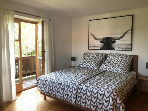 a bedroom with a bed with a cow on the wall at Ferienwohnung Sonnenläng in Hechenberg