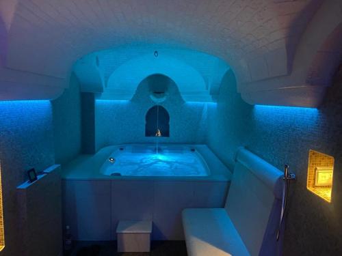 a bathroom with a tub with a blue lighting at Villa Angelina in Selva di Fasano
