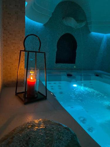a candle in a bath tub with a lantern in it at Villa Angelina in Selva di Fasano