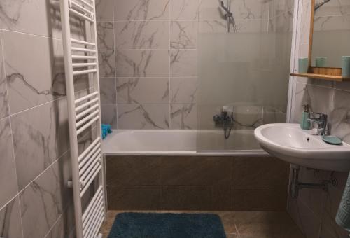 ein Badezimmer mit einer Badewanne und einem Waschbecken in der Unterkunft Gesamte Unterkunft über den Dächern Wiens in Wien