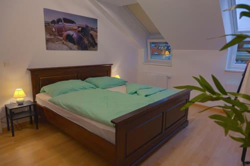 維也納的住宿－Gesamte Unterkunft über den Dächern Wiens，一间卧室配有一张带绿色床单的床,墙上挂有一辆汽车