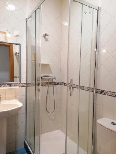 a bathroom with a shower and a sink at Hospedaria Dona Maria in Beja