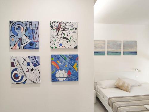 vier Gemälde hängen an einer Wand in einem Raum in der Unterkunft Casa del Mare in Santa Marinella