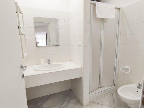 ein weißes Bad mit einem Waschbecken und einem WC in der Unterkunft Casa del Mare in Santa Marinella