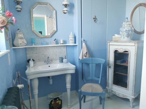 niebieska łazienka z umywalką i lustrem w obiekcie VILLA LES CAMELIAS w mieście Fontaine-lès-Vervins