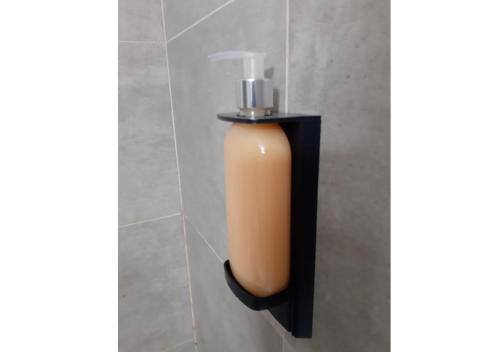 a soap dispenser on a wall in a bathroom at Departamento en el centro de Bariloche Dx in San Carlos de Bariloche
