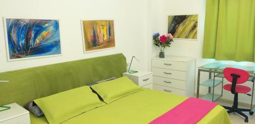 a bedroom with a bed and a desk and paintings at Аpartment 1 bedroom center of Las Americas El Dorado in Playa de las Americas