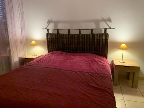 um quarto com uma cama vermelha e 2 candeeiros nas mesas em Villa 5 min circuit Paul-Ricard et 20 mn de la Mer em Signes