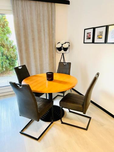a dining room with a wooden table and chairs at HappyLivingApartments in Villach