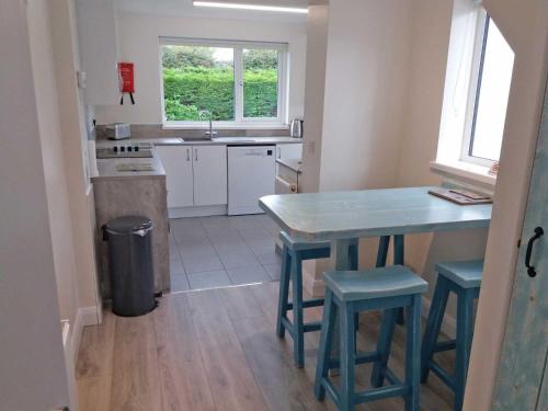 una cocina con una mesa azul y taburetes. en Lough Conn Holiday Home, en Crossmolina