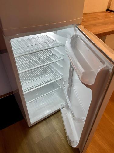 an empty refrigerator with its door open in a kitchen at HappyLivingApartments in Villach
