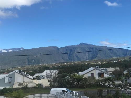 uma vista para uma casa com montanhas ao fundo em Chez - Dom em Le Tampon