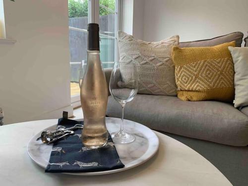 una botella de vino y una copa en una mesa en Stylish & Spacious 3 Bed House With 2 Free Car Parking Spaces, en Appledram