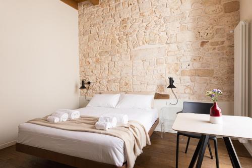 a bedroom with a bed and a brick wall at Casa Badia Bed & Breakfast in Conversano