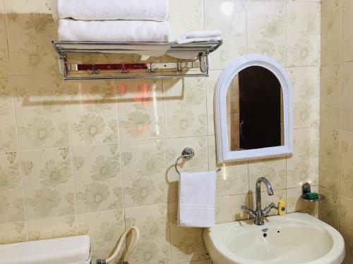 a bathroom with a sink and a mirror at Rose Cottage - A Heritage Retreat in Mount Ābu