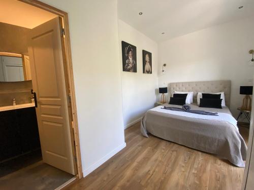 una camera da letto con un letto grande e un pavimento in legno di HOME SWEET HOME 2 pièces 42 m2 Chambre, salon, cuisine, grande terrasse, parking proche centre ville et mer a Bastia