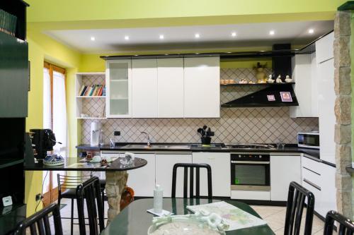 a kitchen with white cabinets and a table and chairs at Le Ali del Vento in Cairano
