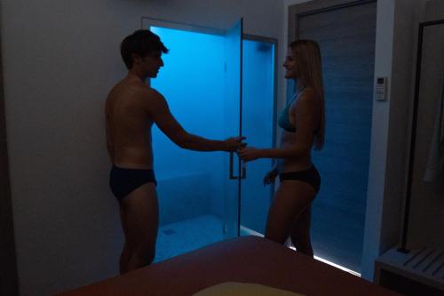 a man and a woman standing in front of a mirror at Romeo Giulietta Rooms Apartments Turkish Bath in Verona