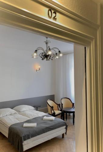 a bedroom with a bed and a chandelier at Hôtel D’Artiste in Pierrefontaine-les-Varans