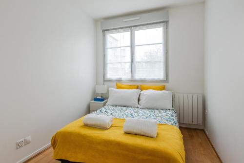 a bedroom with a bed with yellow sheets and a window at Chez patron T4 3BR near Disneyland and train station-Montévrain in Montévrain