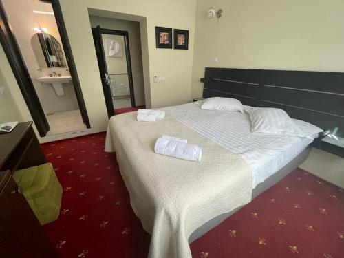a hotel room with a bed with two towels on it at Casa Bucovineana in Suceava