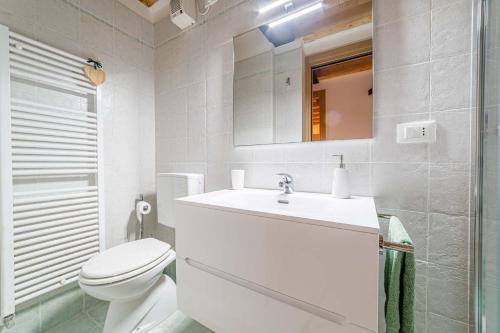a white bathroom with a sink and a toilet at Charming Civetta in Alleghe